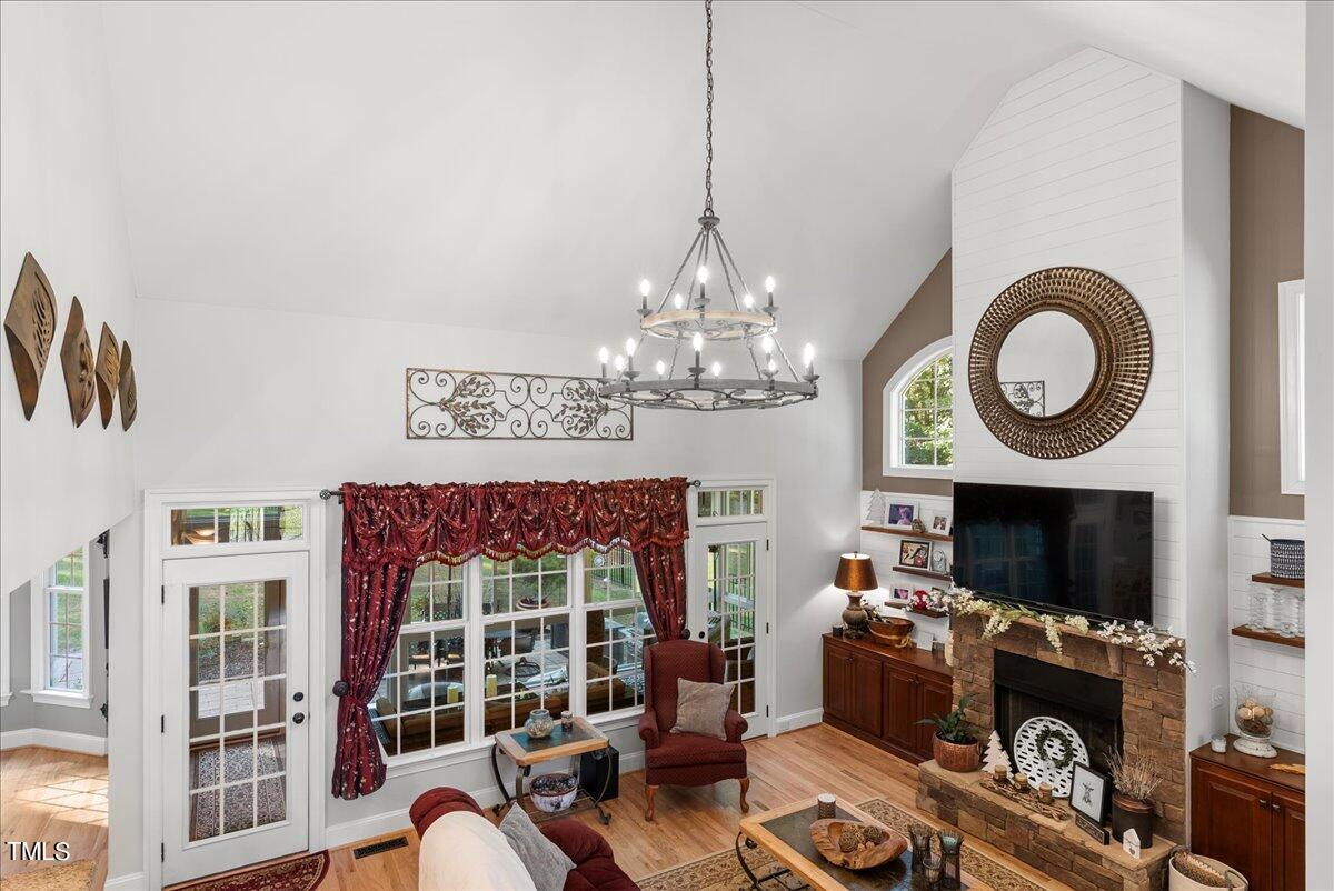 105 Jackson Road Youngsville, NC 27596 - Photo 18 of 55 a living room with furniture a chandelier and a flat screen tv