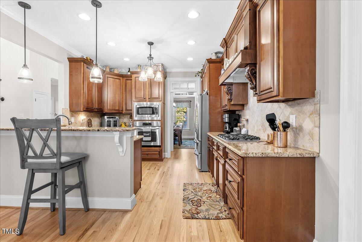105 Jackson Road Youngsville, NC 27596 - Photo 10 of 55 a kitchen with granite countertop kitchen island stainless steel appliances a dining table chairs sink and cabinets
