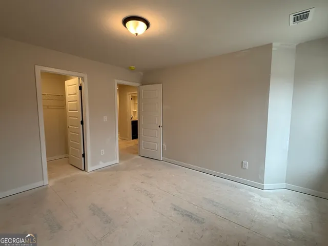 an empty room with closet and mirror