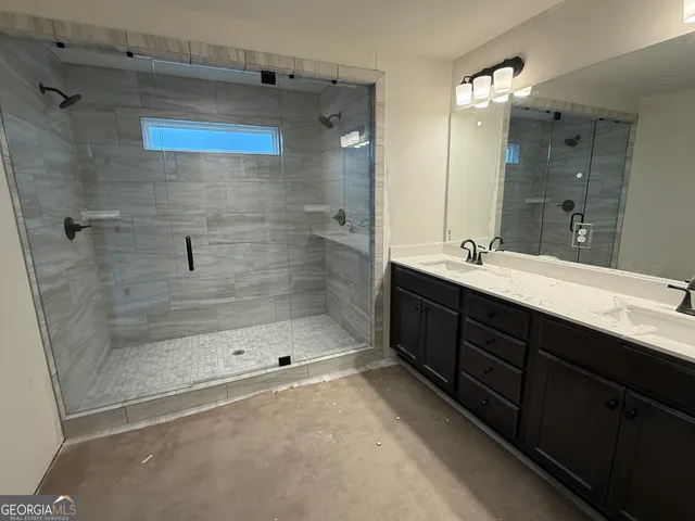a bathroom with a double vanity sink mirror and shower