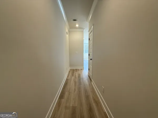 a view of a hallway with wooden floor