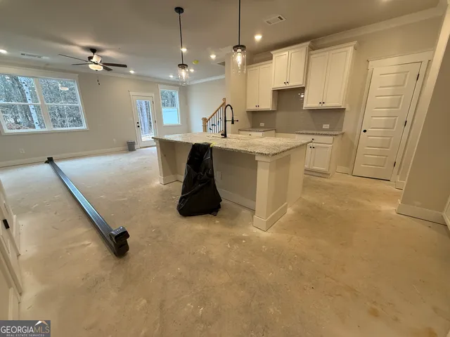 a large white kitchen with a sink stainless steel appliances and cabinets