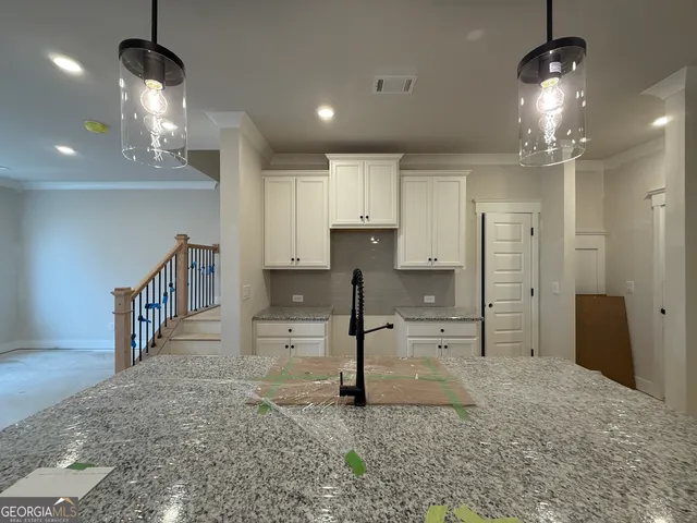 a view of a kitchen with a sink and chandelier
