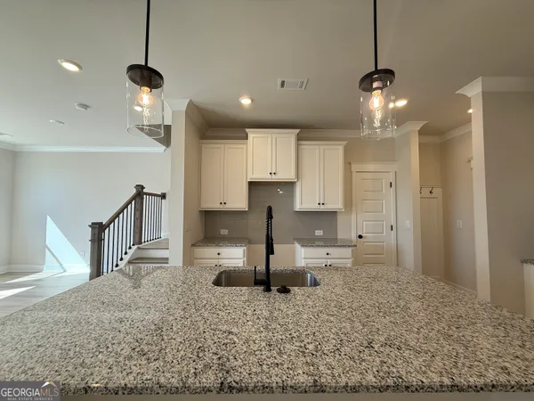 a large kitchen with stainless steel appliances kitchen island granite countertop a refrigerator a sink and a stove