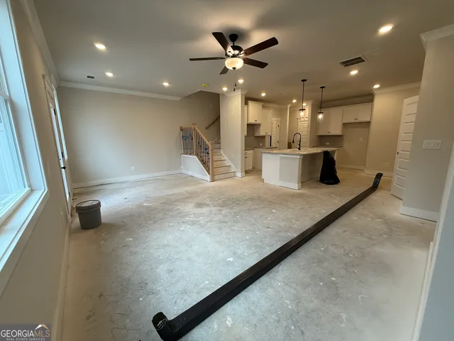 a large kitchen with stainless steel appliances a large counter top a stove and a sink