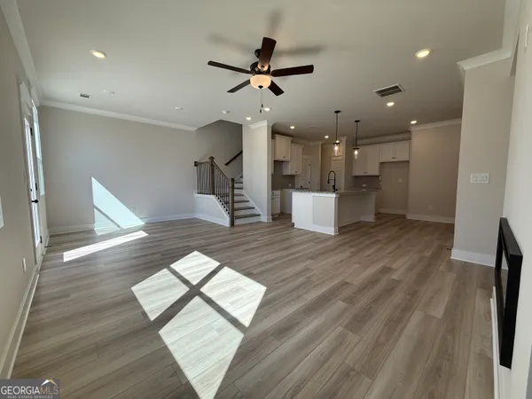 a view of a living room a dining room wooden floor and a ceiling fan
