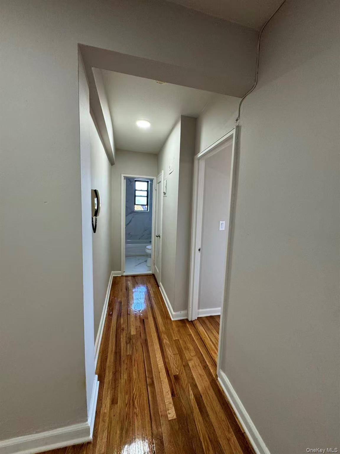 99-63 66th Avenue, Unit C14 Queens, NY 11374 - Photo 2 of 6 Hallway featuring hardwood / wood-style flooring and baseboards