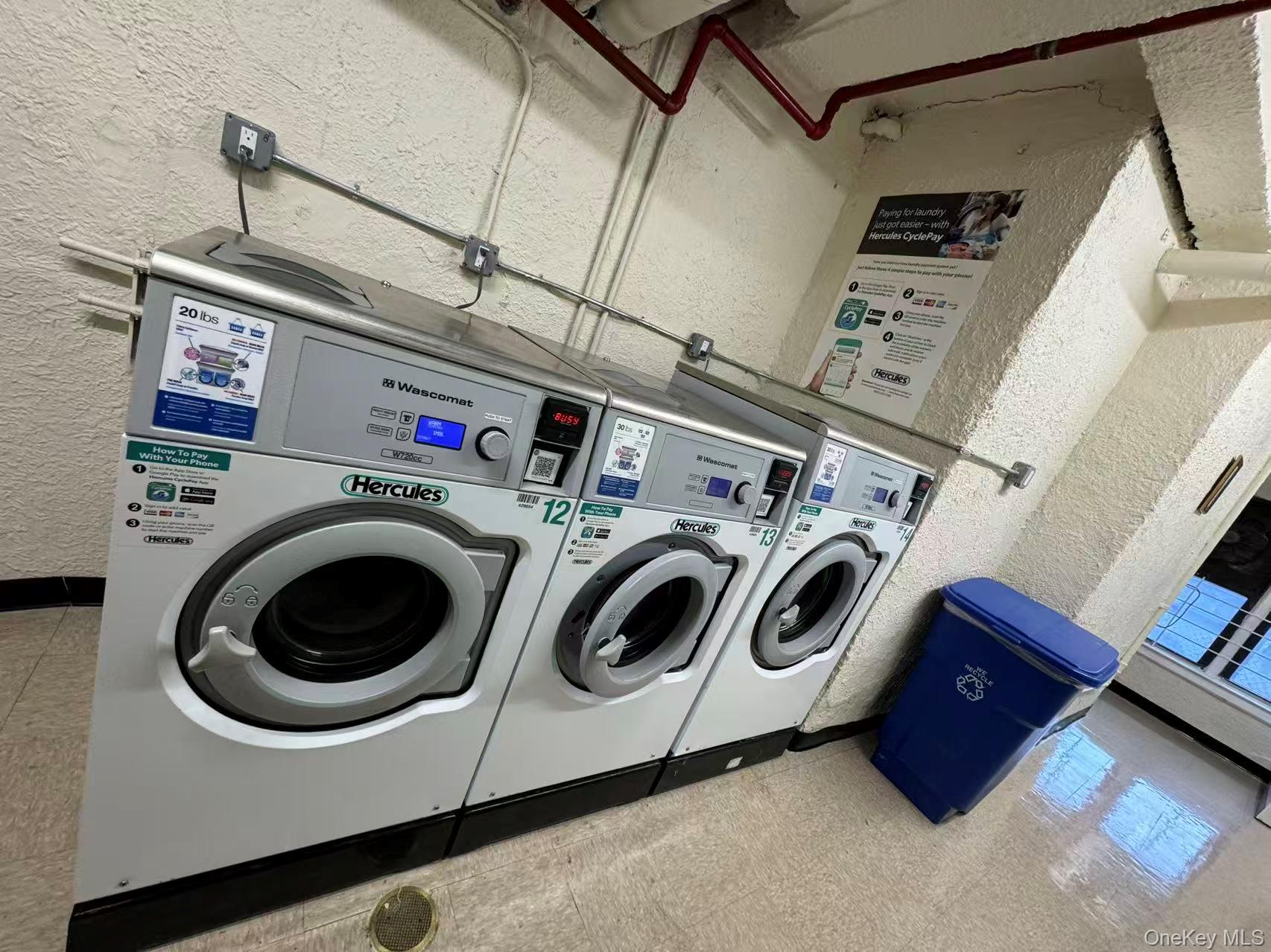 99-63 66th Avenue, Unit C14 Queens, NY 11374 - Photo 6 of 6 Shared laundry room with a textured wall and washing machine and dryer