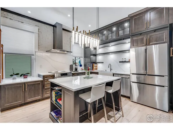 a kitchen with stainless steel appliances a sink a stove a refrigerator and cabinets