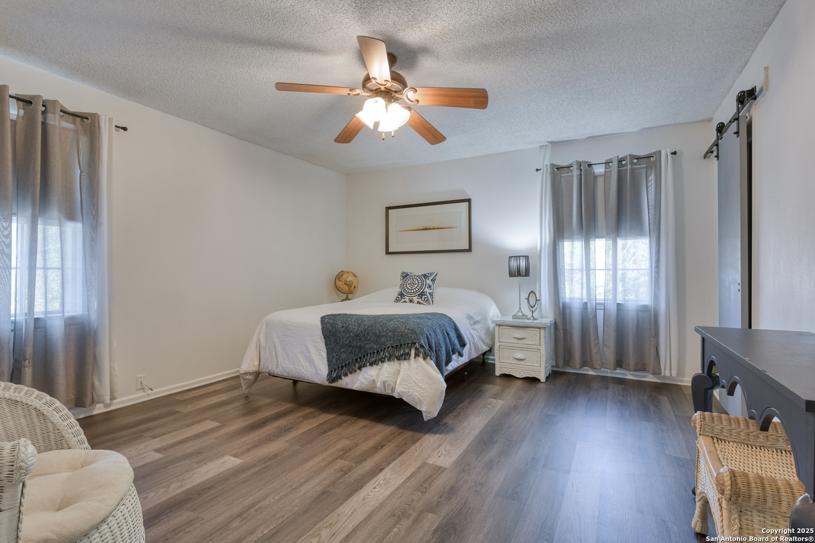 8715 Starcrest, Unit 58 San Antonio, TX 78217 - Photo 12 of 30 a spacious bedroom with a bed and a chandelier
