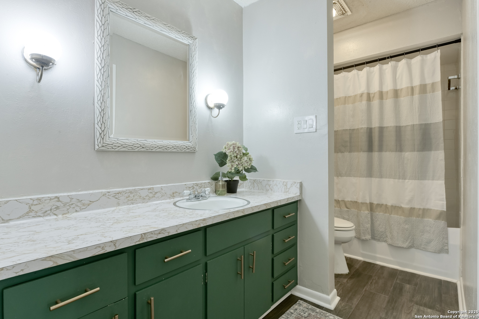 8715 Starcrest, Unit 58 San Antonio, TX 78217 - Photo 13 of 30 a bathroom with a granite countertop sink a toilet and a mirror