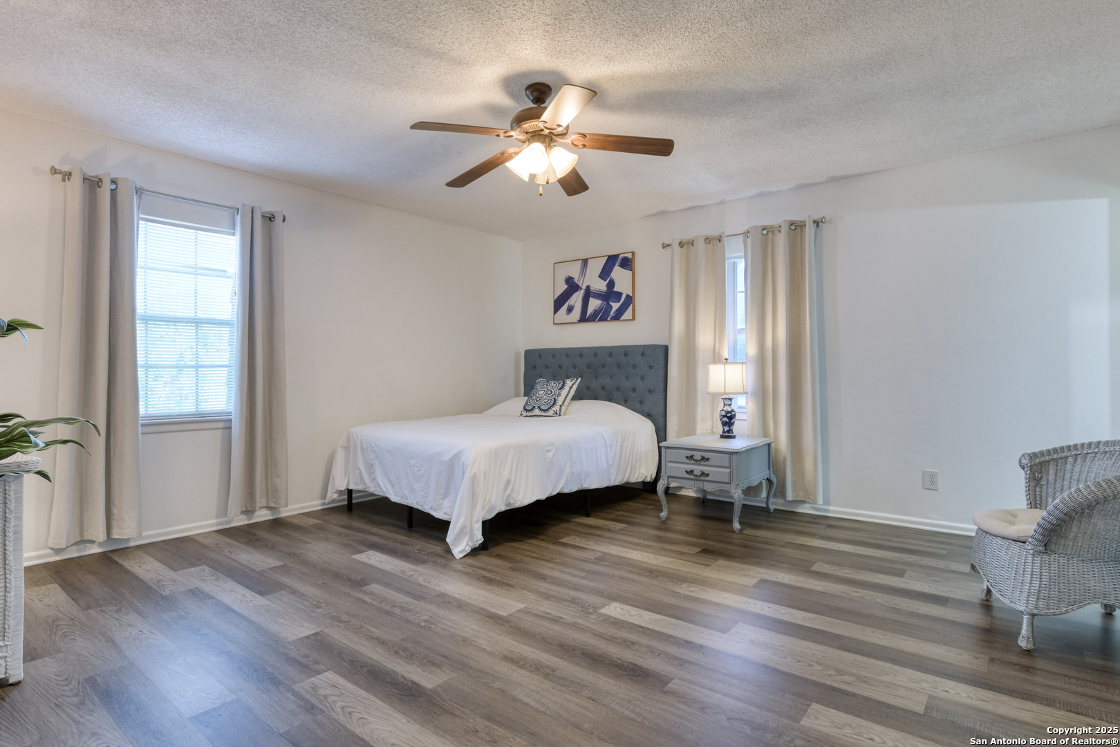 8715 Starcrest, Unit 58 San Antonio, TX 78217 - Photo 14 of 30 a spacious bedroom with a bed and a chandelier