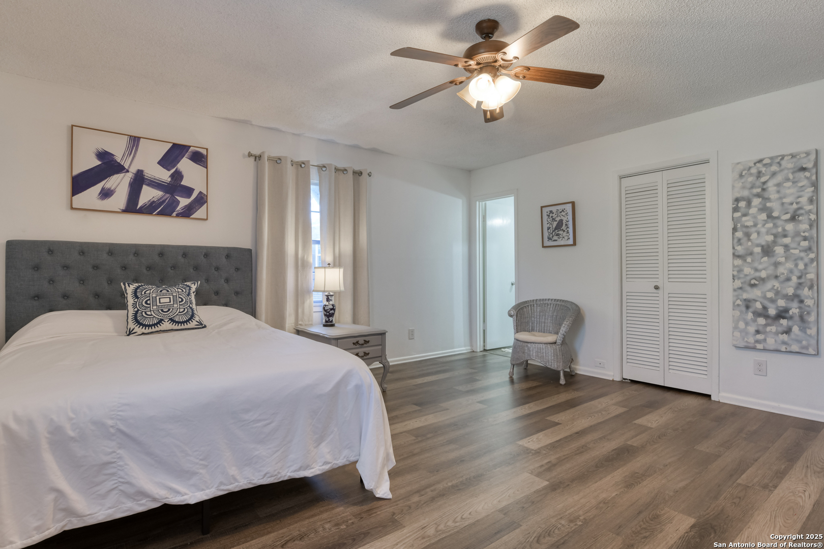 8715 Starcrest, Unit 58 San Antonio, TX 78217 - Photo 15 of 30 a bedroom with a bed and a chandelier