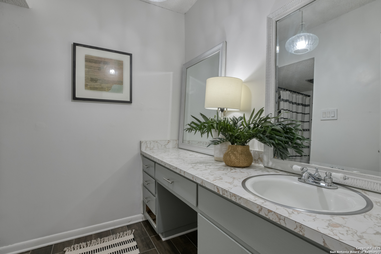 8715 Starcrest, Unit 58 San Antonio, TX 78217 - Photo 16 of 30 a bathroom with a granite countertop sink a mirror and vanity