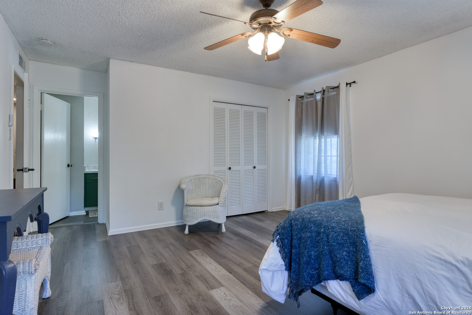 8715 Starcrest, Unit 58 San Antonio, TX 78217 - Photo 27 of 30 a spacious bedroom with a bed and a chandelier