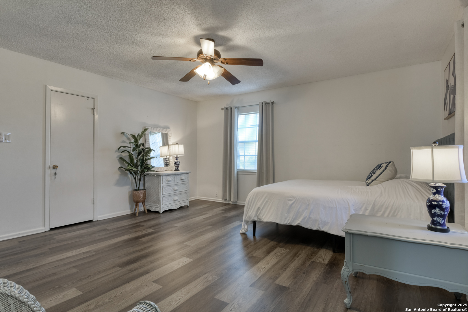 8715 Starcrest, Unit 58 San Antonio, TX 78217 - Photo 28 of 30 a spacious bedroom with a bed and a chandelier