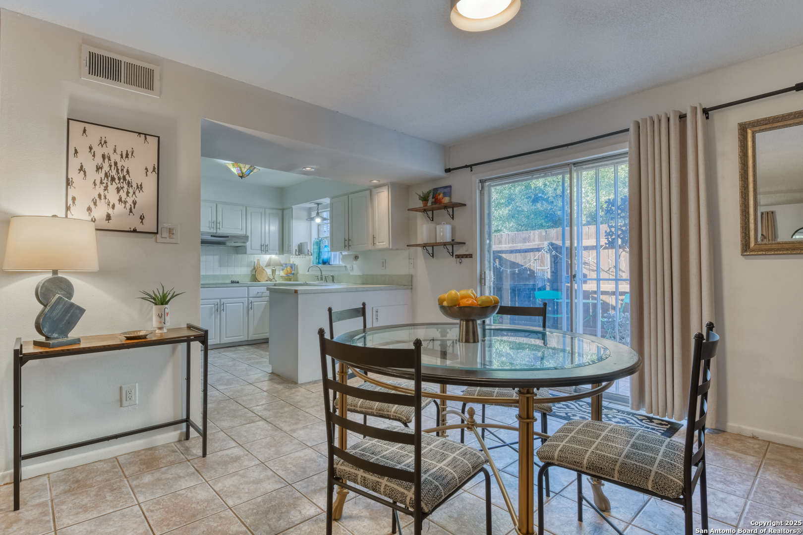 8715 Starcrest, Unit 58 San Antonio, TX 78217 - Photo 6 of 30 a kitchen with a dining table chairs and refrigerator