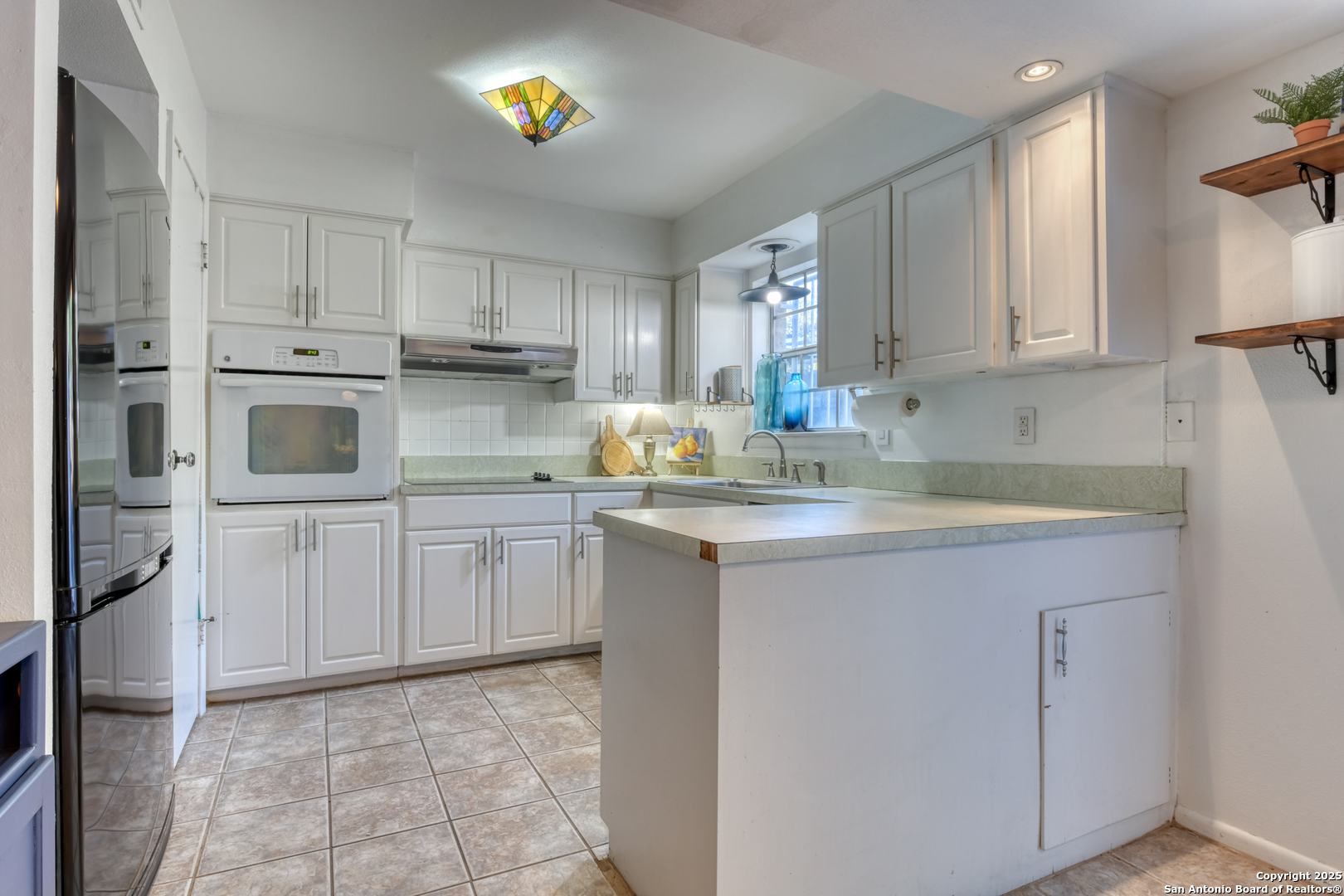 8715 Starcrest, Unit 58 San Antonio, TX 78217 - Photo 8 of 30 a kitchen with cabinets and window