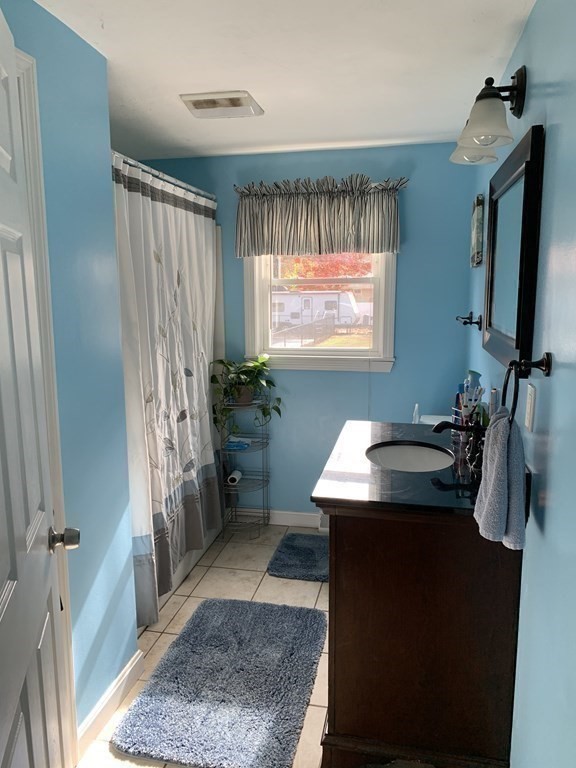 63 Lowell Road Pepperell, MA 01463 - Photo 17 of 32 a bathroom with a sink a toilet and mirror
