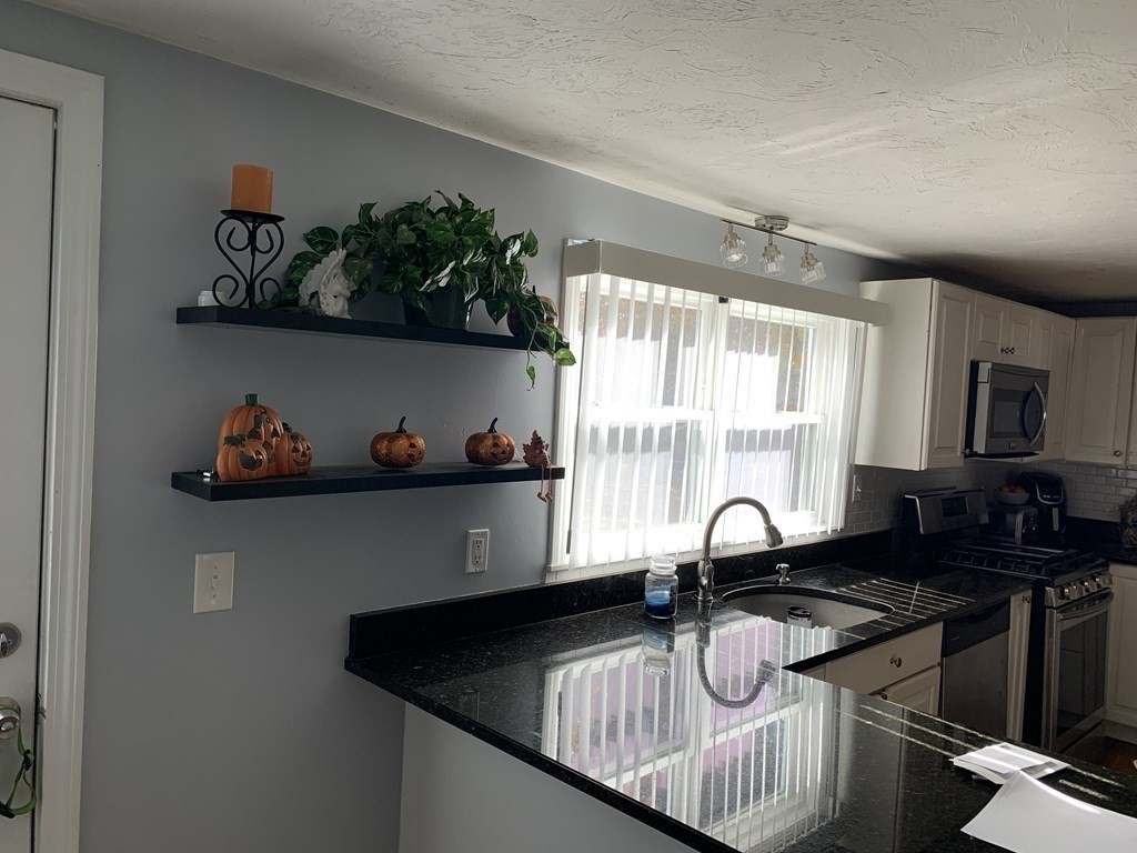 63 Lowell Road Pepperell, MA 01463 - Photo 6 of 32 a kitchen with a sink and a stove top oven