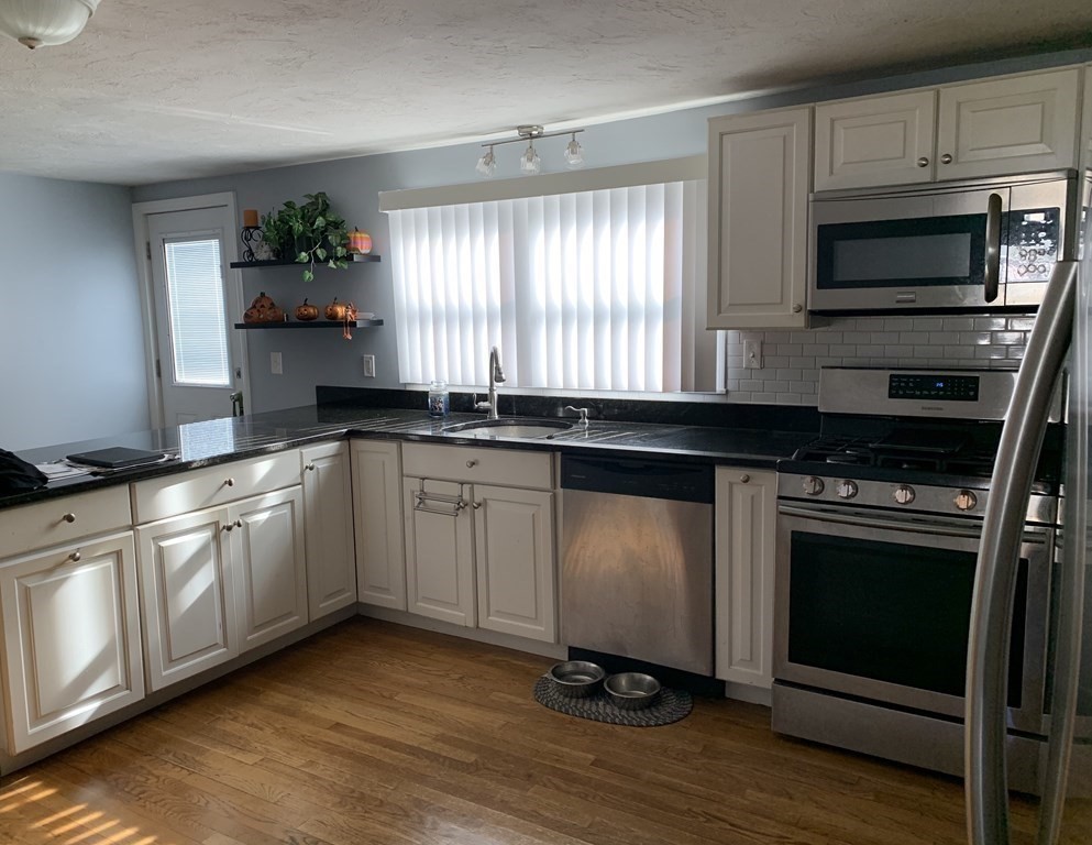 63 Lowell Road Pepperell, MA 01463 - Photo 7 of 32 a kitchen with granite countertop cabinets stainless steel appliances and a window