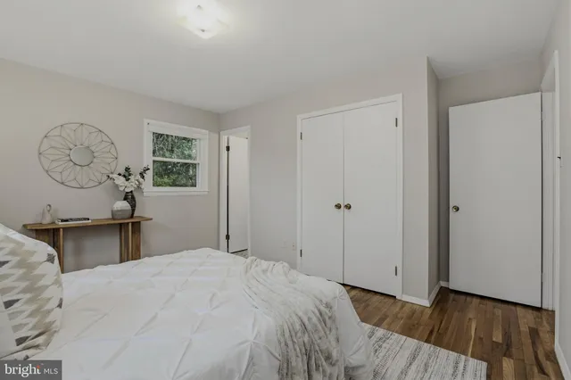 a bedroom with a large bed and wooden floor