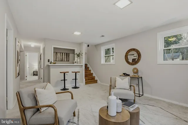 a living room with furniture a chandelier and a window