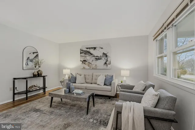 a living room with furniture a rug and a large window