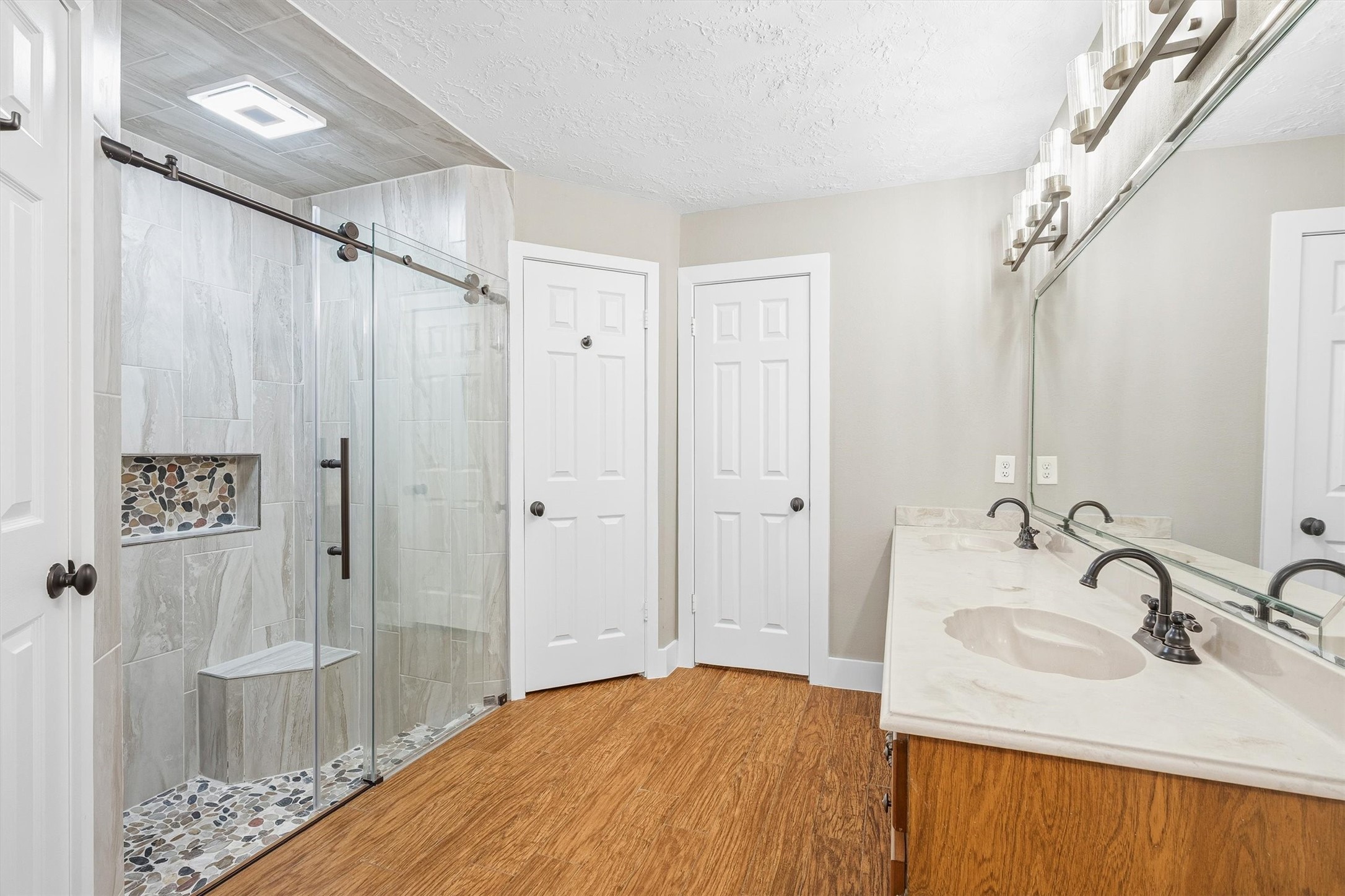 826 North Rivershire Drive Conroe, TX 77304 - Photo 22 of 46 Large format tile surround, pebble tile floor, frameless glass enclosure with barn style hardware, and a built-in niche. This shower is the kind of upgrade that stays with you.