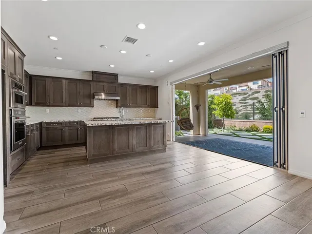 a large kitchen with granite countertop a large counter top stainless steel appliances and cabinets