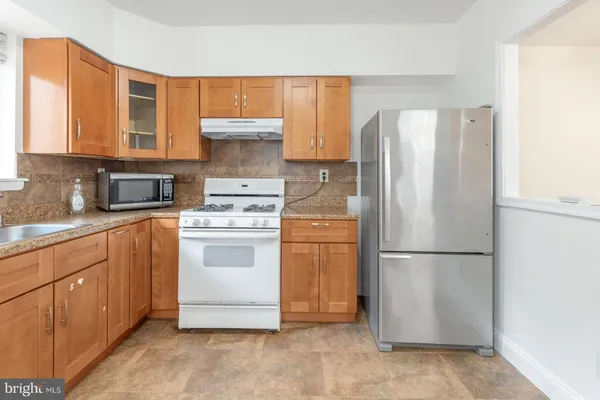 a kitchen with a refrigerator sink stove and cabinets