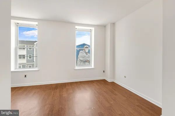 an empty room with wooden floor and window