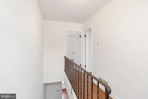 a view of a hallway with wooden floor and entryway