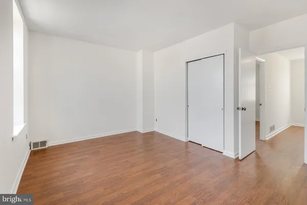 a view of empty room with wooden floor