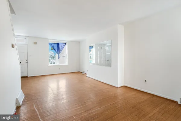 an empty room with wooden floor and window