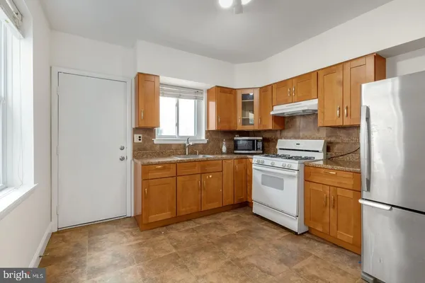 a kitchen with stainless steel appliances a refrigerator sink and cabinets