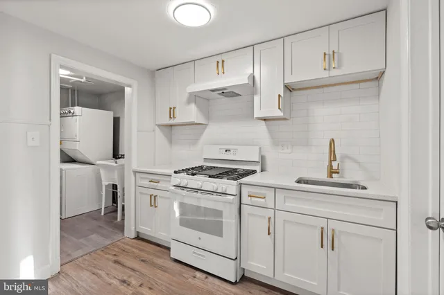 a kitchen with cabinets appliances and wooden floor