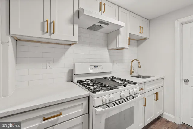 a white stove top oven sitting inside of a kitchen