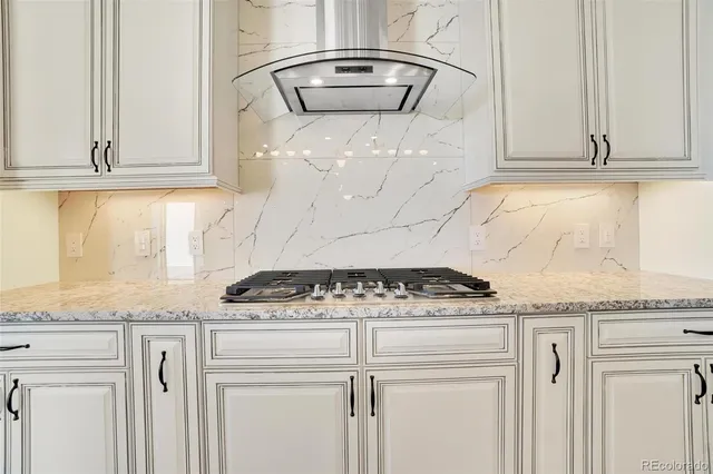 a kitchen with granite countertop white cabinets and a stove