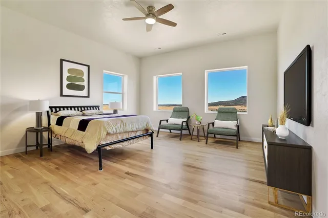 a spacious bedroom with a bed and a flat screen tv
