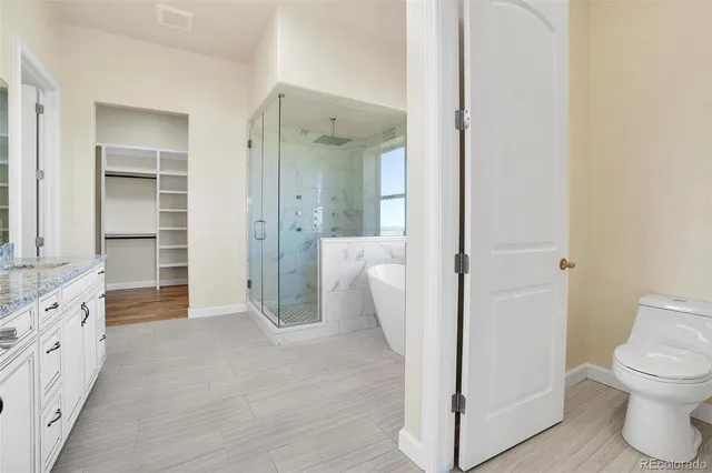 a view of a bathroom with toilet shower and wooden floor