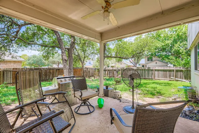 a view of a patio with table and chairs and a large tree