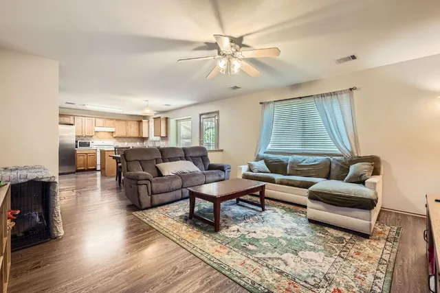 a living room with furniture and a wooden floor