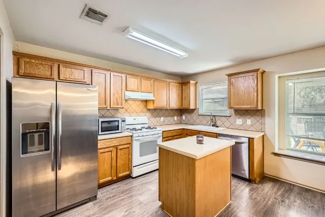 a kitchen with a refrigerator a sink and cabinets