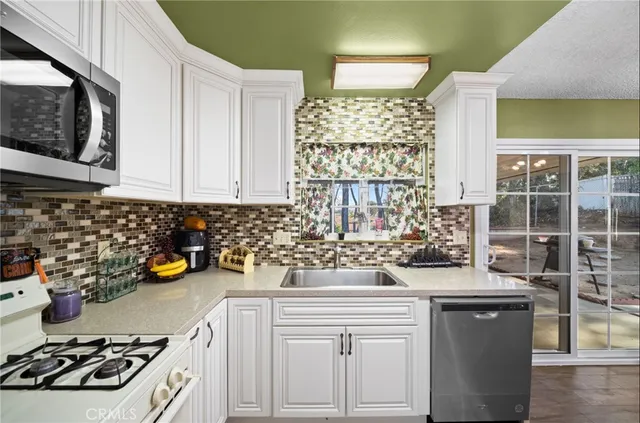 a kitchen with a stove a sink and cabinets
