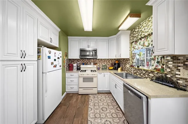 a kitchen with white cabinets and white appliances