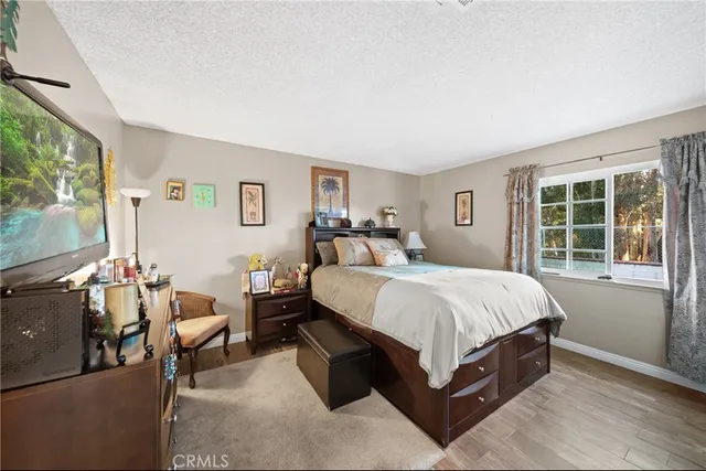 a spacious bedroom with a bed and a flat screen tv