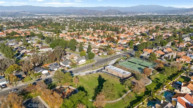 an aerial view of residential house with outdoor space and trees all around