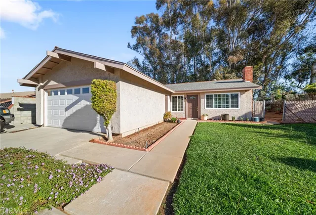 a view of a house with a yard and potted plants