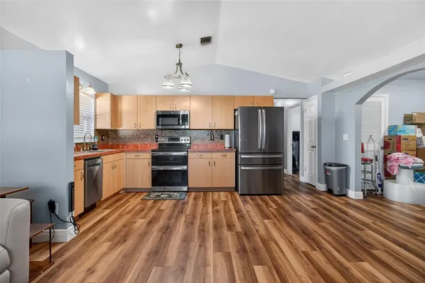 a kitchen with stainless steel appliances a refrigerator sink and microwave